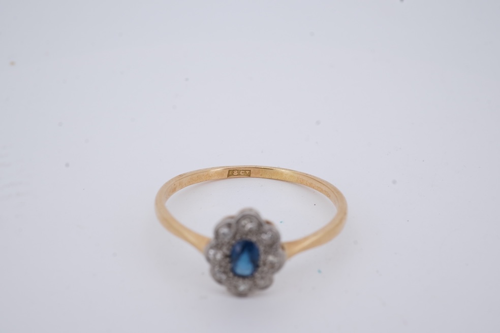 A 1920's yellow metal, stamped 18ct, sapphire and diamond set oval cluster ring, size V, gross weight 2.3 grams. Condition - poor to fair